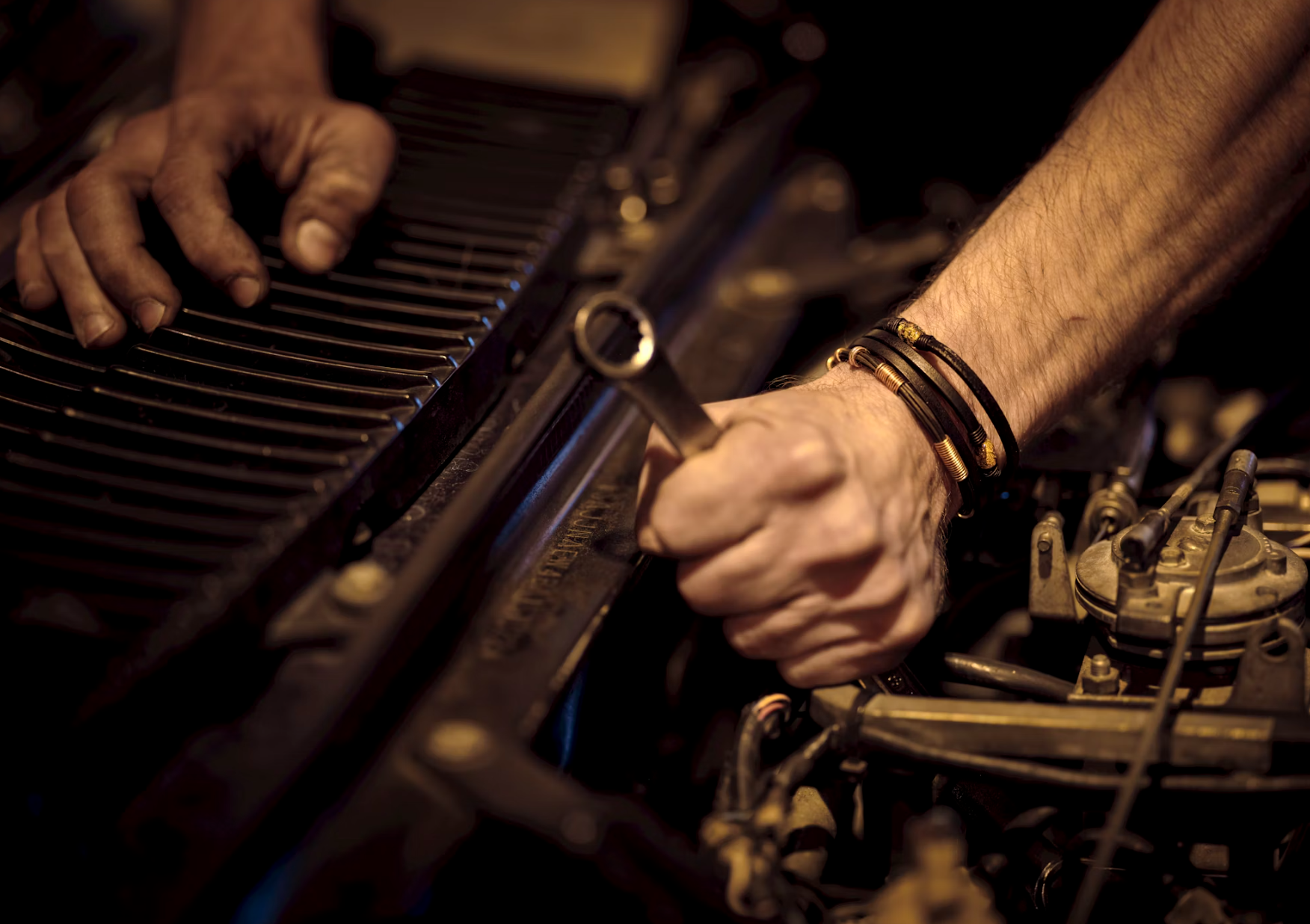 Mechanic working on an engine with a wrench